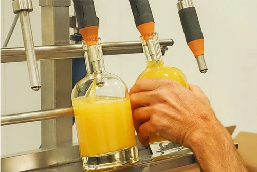Mise en bouteille de jus d'orange au domaine de la mer blanche.