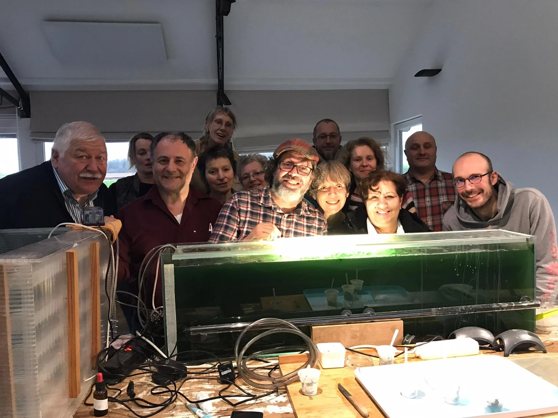 Photo des participants avec le formateur devant un bassin de spiruline durant la formation culture de spiruline initiation.