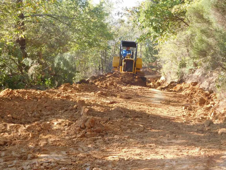 Photo d'un aménagement hydraulique d'un territoire en fonction du sol. Un tracteur creuse dans sol.