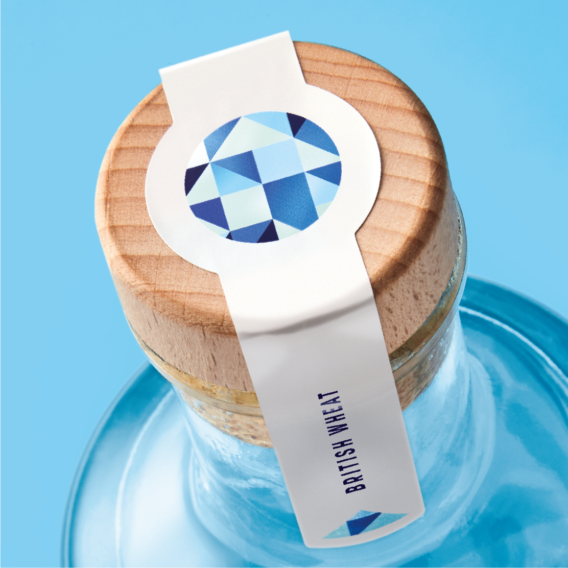 A close-up image of the top of a Bonmi vodka bottle, showcasing a wooden cap with a decorative blue and white design, and a label partially visible around the neck.