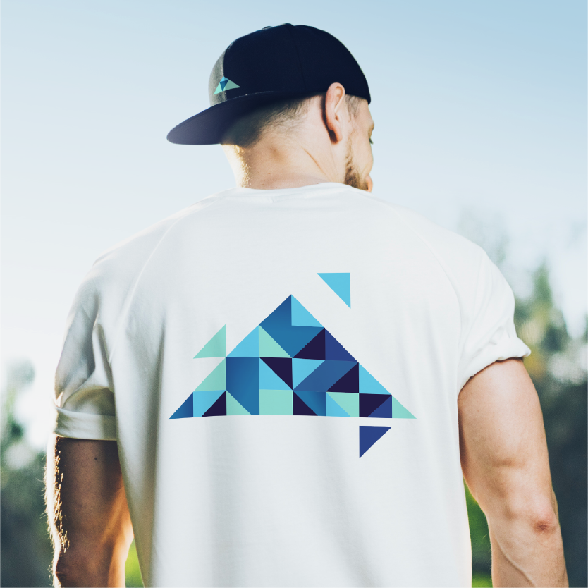 Man wearing a white t-shirt with a blue geometric triangle design on the back.