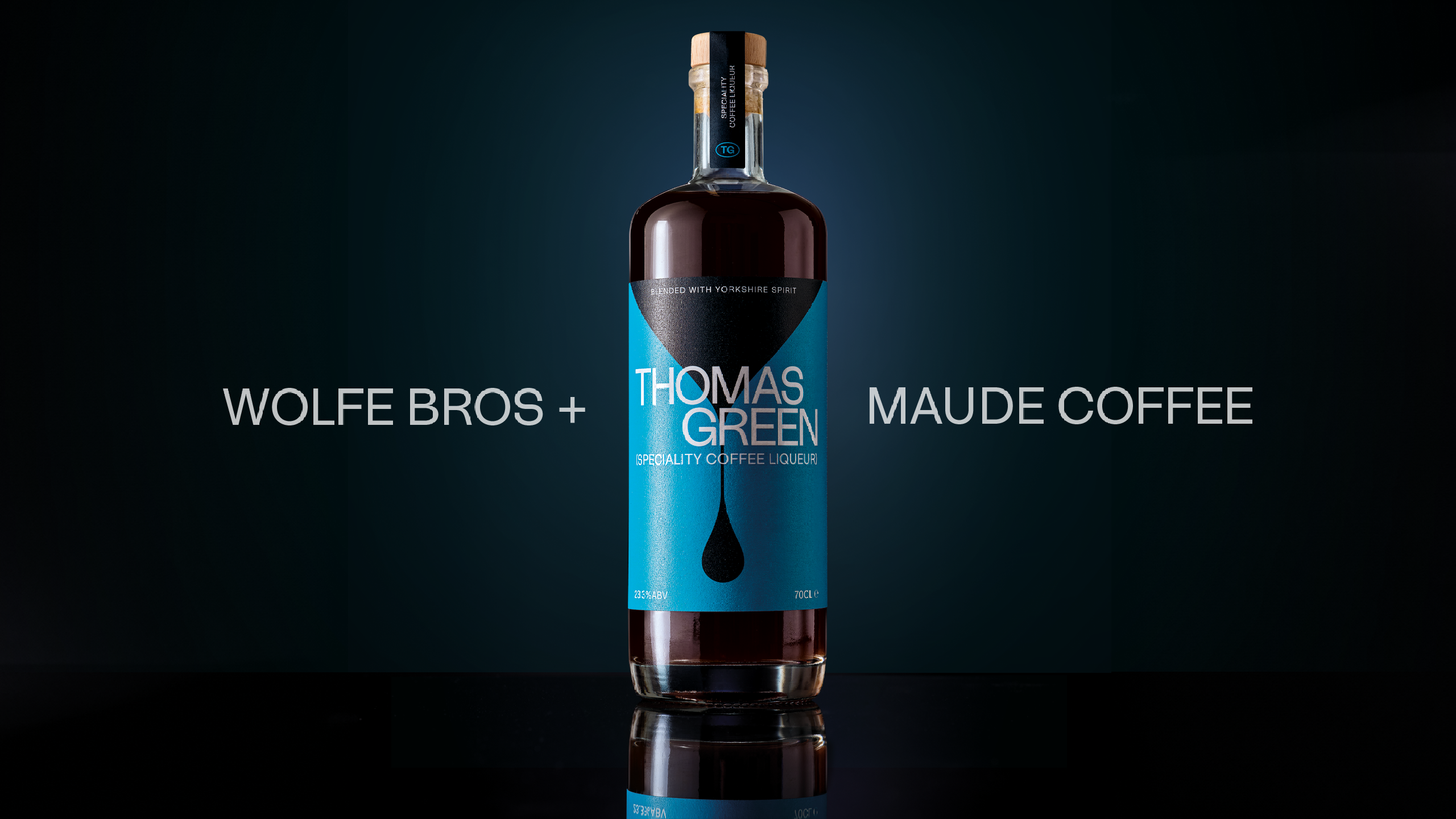 Bottle of Thomas Green speciality coffee liqueur with a bright blue label and a coffee drip graphic, made by Wolfe Bros and Maude Coffee.