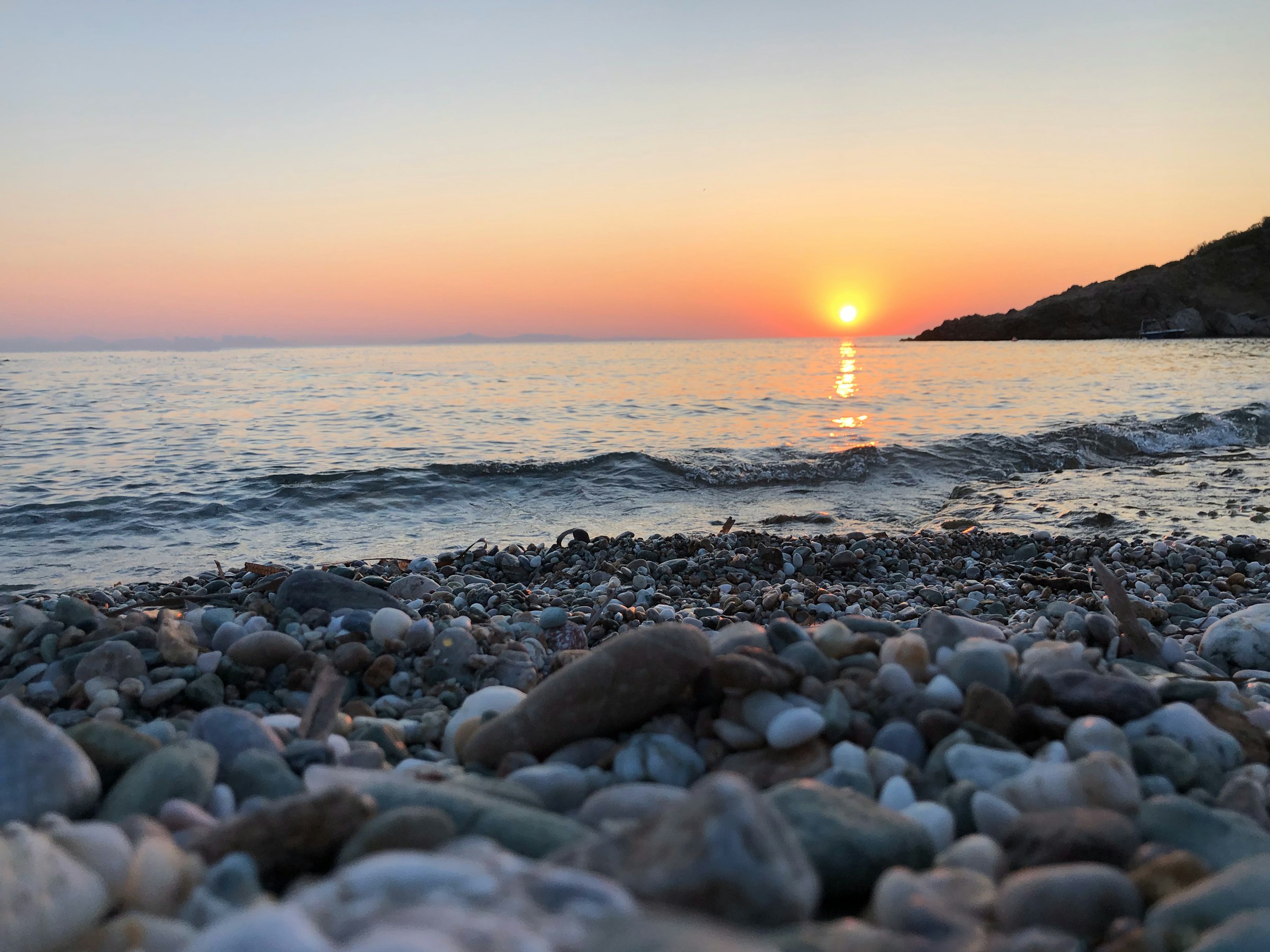 Athens Riviera sunset over rocky beach, Greece