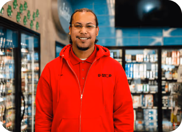 Young male employee portrait shot inside a U-Stop convenience Store.