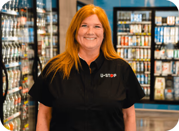 portrait shot of a young woman employee for U-stop convenience shop inside one of their locations in front of the fridge