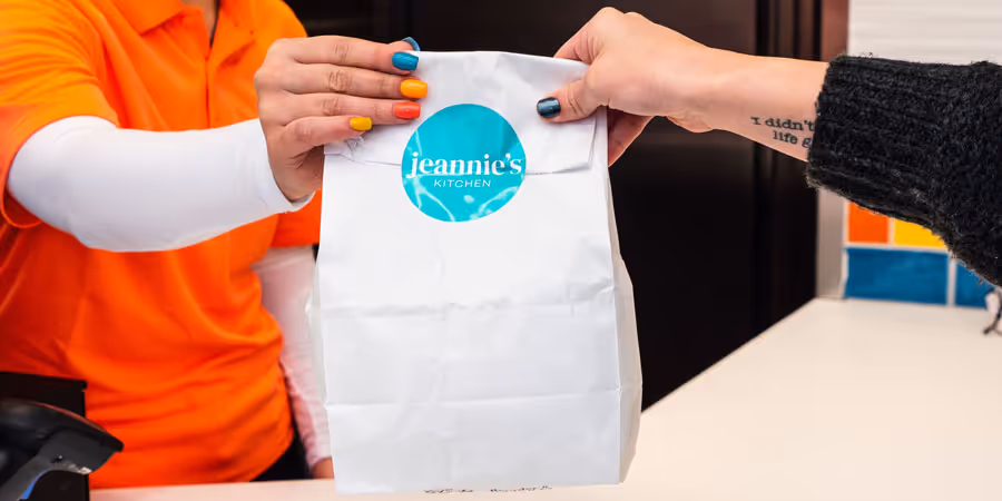 Jeannie's employee handing a customer their meal