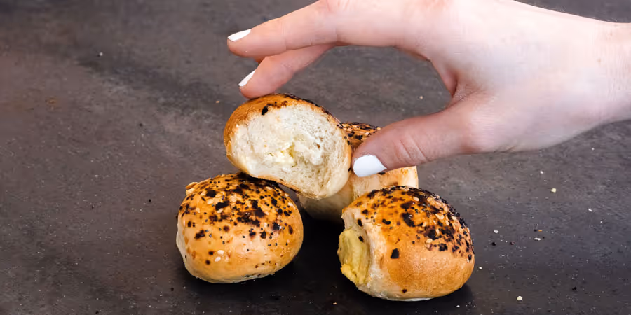 close up of a hand placing a cheese puff ball