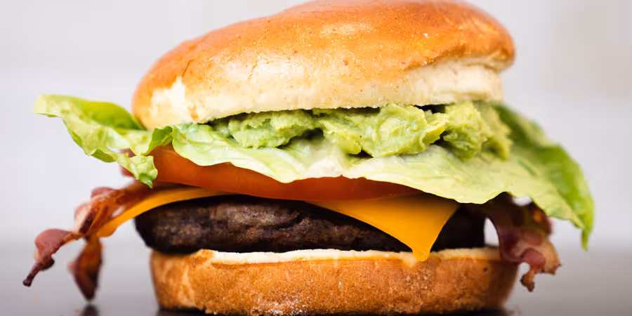 close up of a cheeseburger with bacon and lettuce