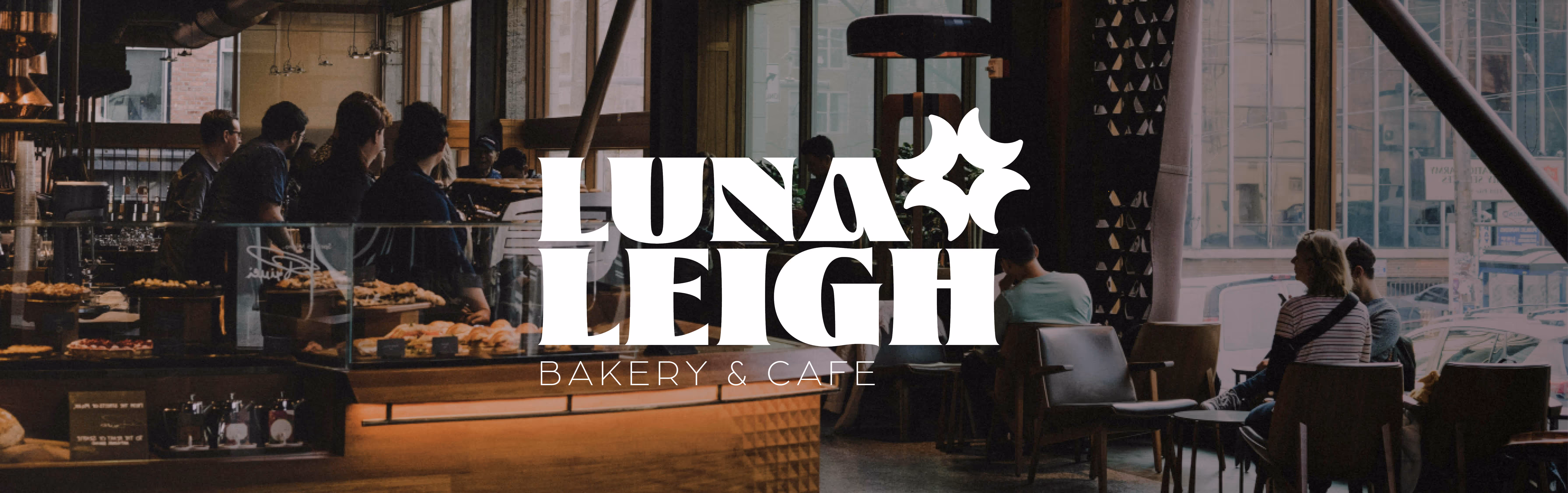 Logo of Luna Leigh Bakery & Cafe over an image of large bakery with people sitting in and many baristas behind the counter