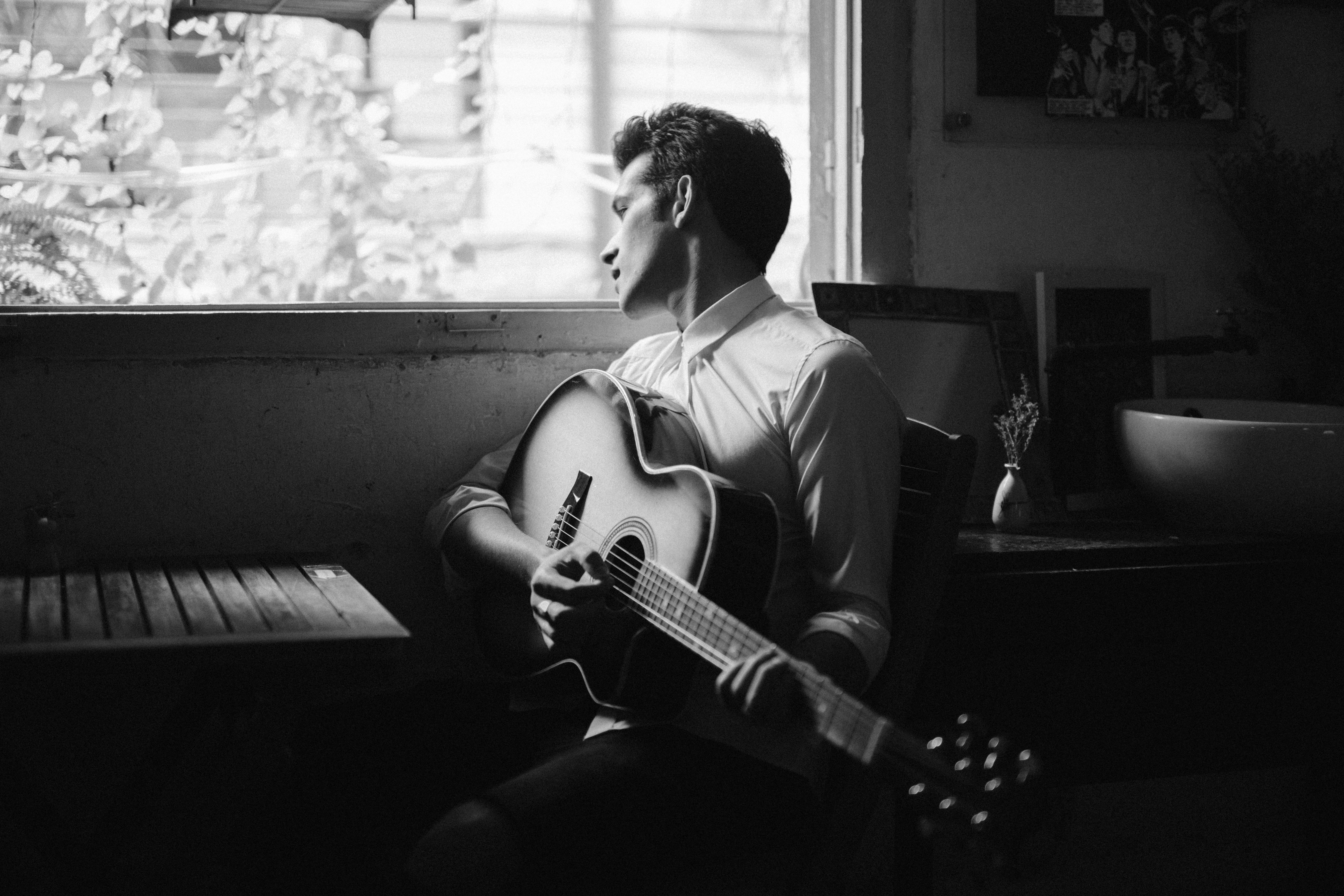 Man playing guitar next to a table