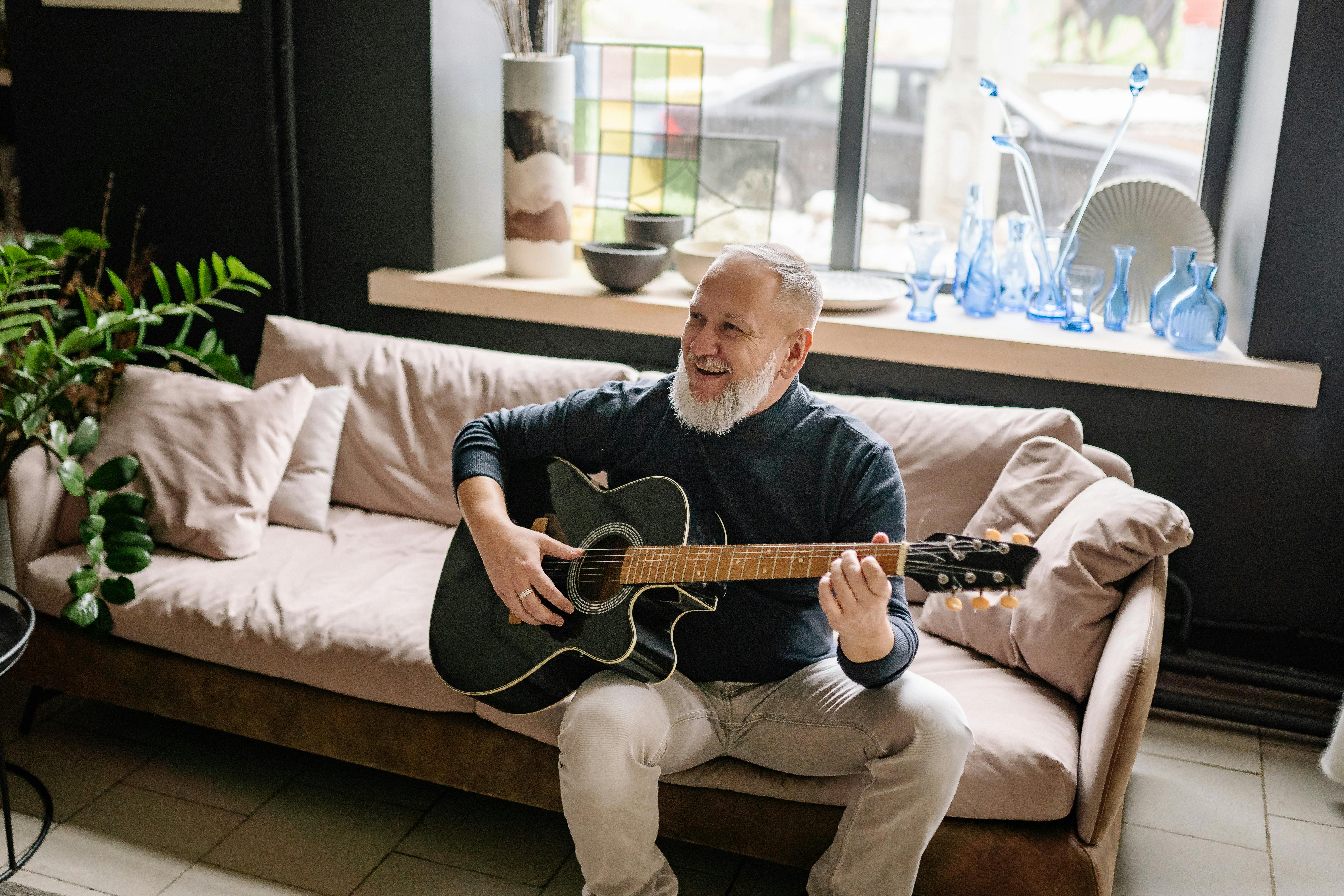 Elderly man playing guitar on a coach