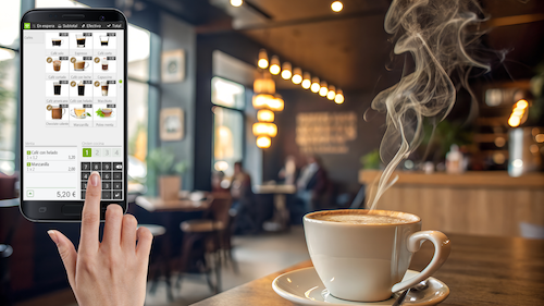 Taza de café servida en cafetería con TPV Hiopos imprimiendo ticket de venta en segundo plano