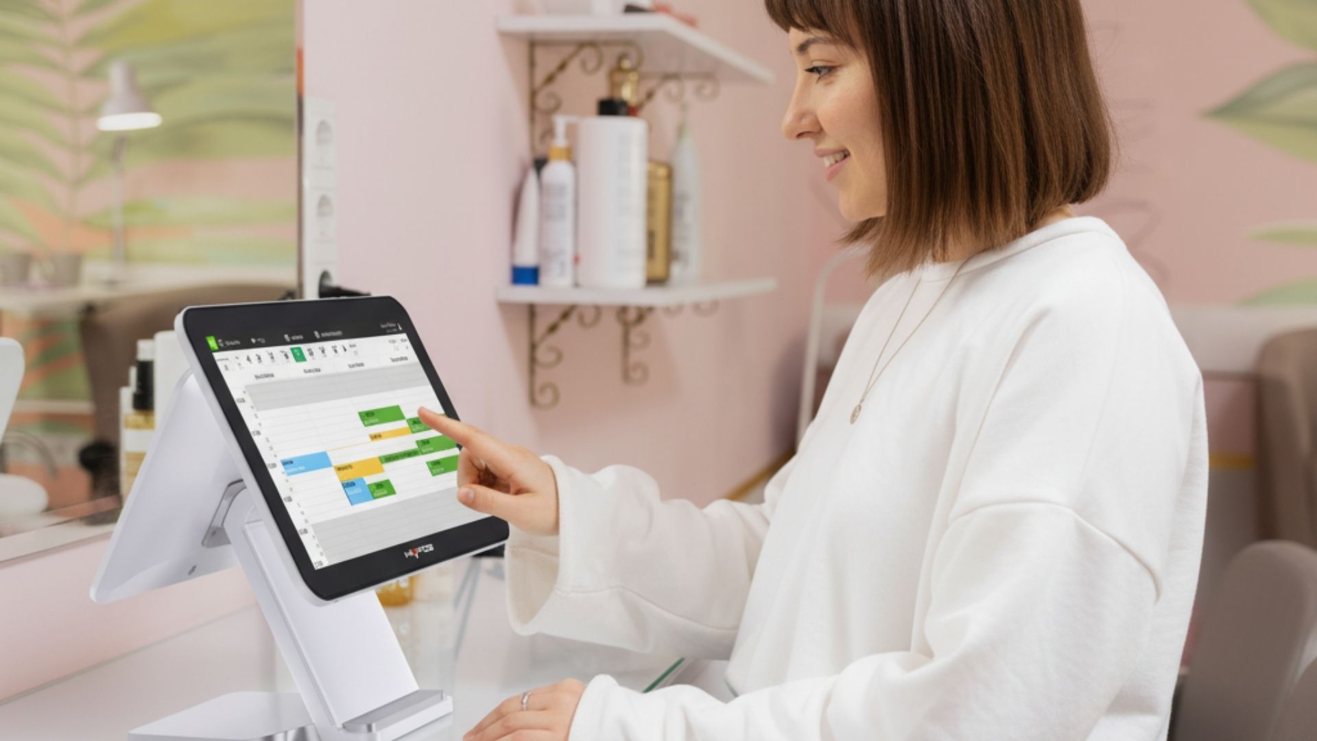 Pantalla táctil TPV para centros de estética mostrando reservas online y control de clientes