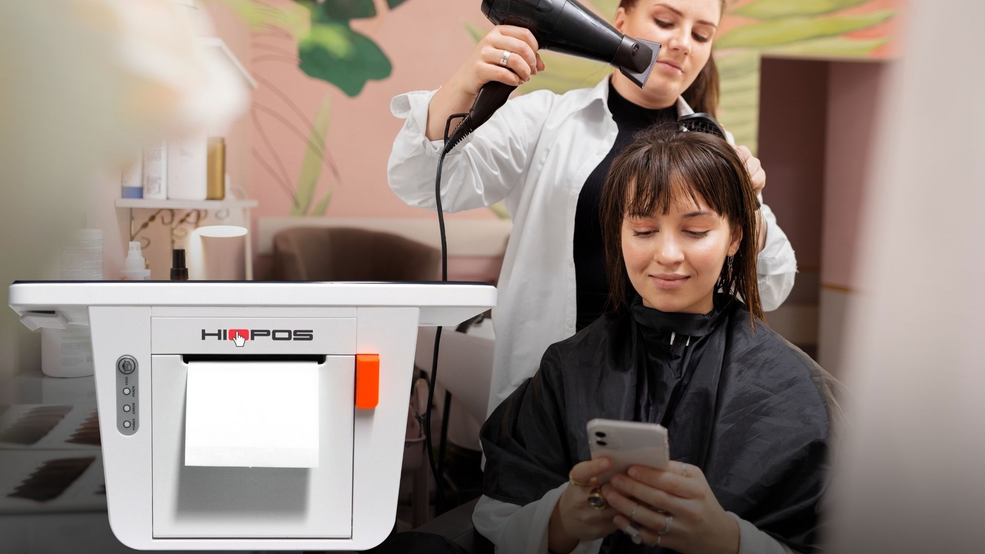 Peluquera atendiendo clienta con TPV Hiopos en primer plano emitiendo ticket Verifactu en salón