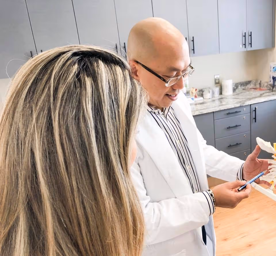 Dr. Bao Tran showing spine imaging to client.
