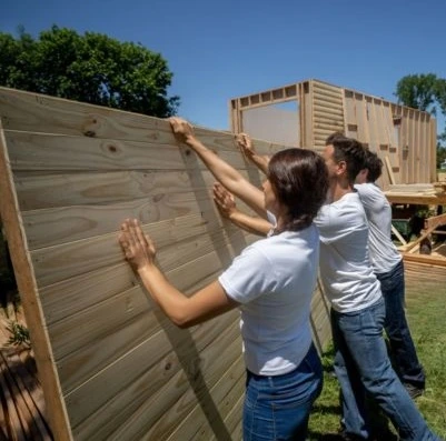 Une photo d'un groupe de personnes en train de construire un éco-habitat pour illustrer le sujet d’étude et les formations sur les éco-habitats.