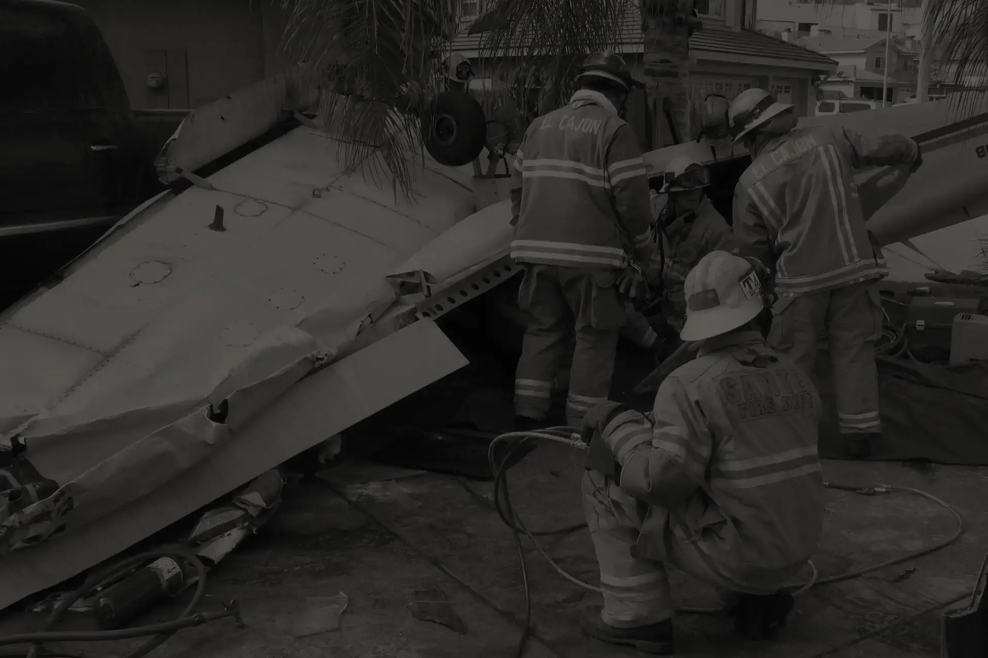 El Cajon and Santee firefighters in gear working at small plane crash site with wreckage in residential area in San Diego.