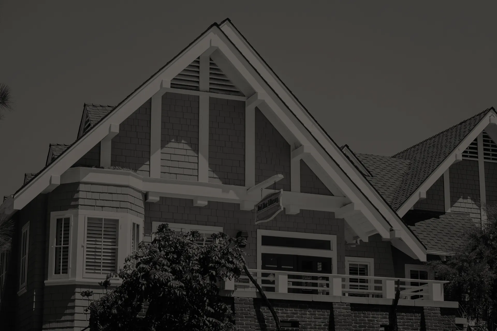 Del Mar library building with steep gabled roof, shingle siding, white trim, and a balcony with railing.