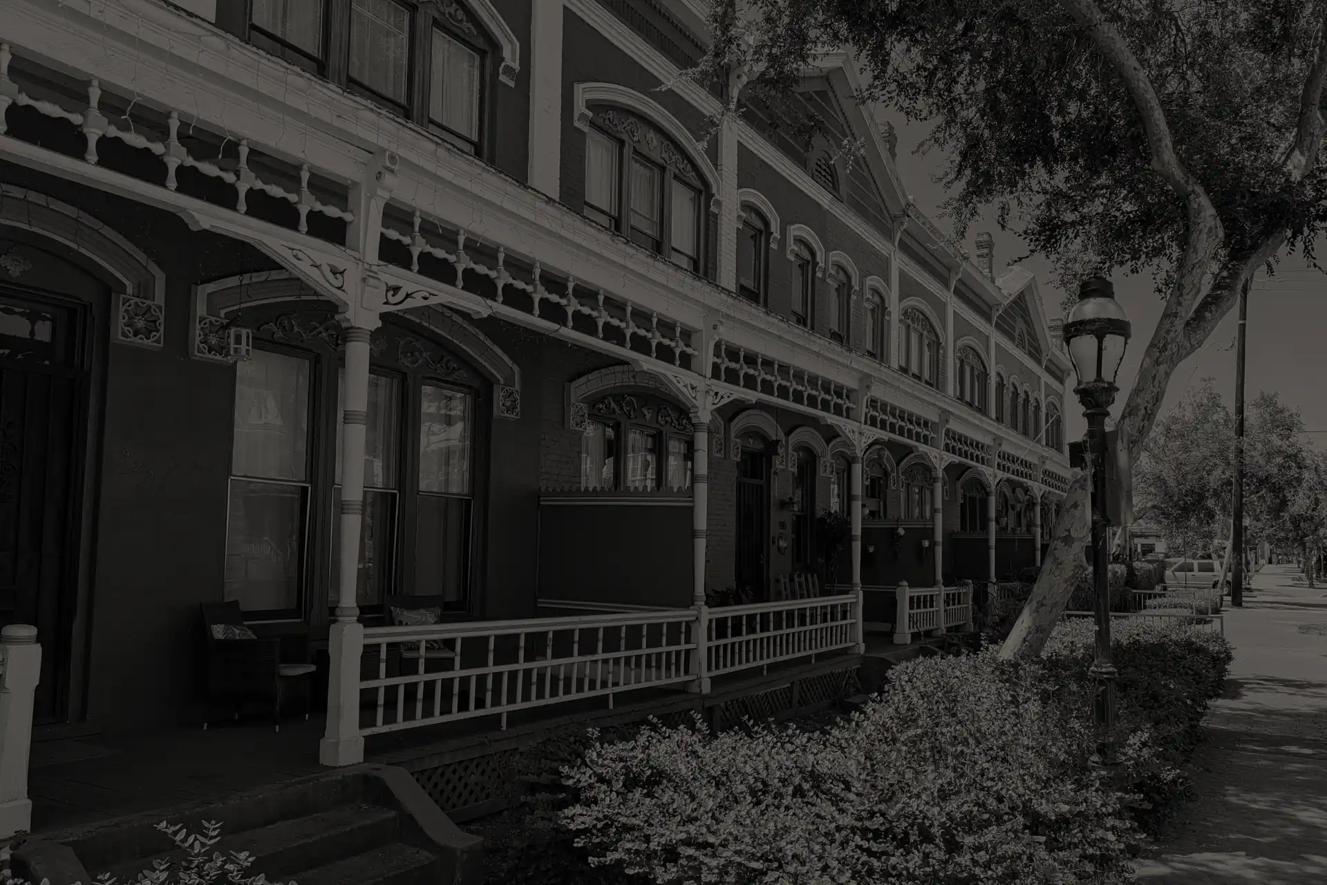 Brick Row in National City historic brick houses with decorative woodwork porches along a tree-lined sidewalk.