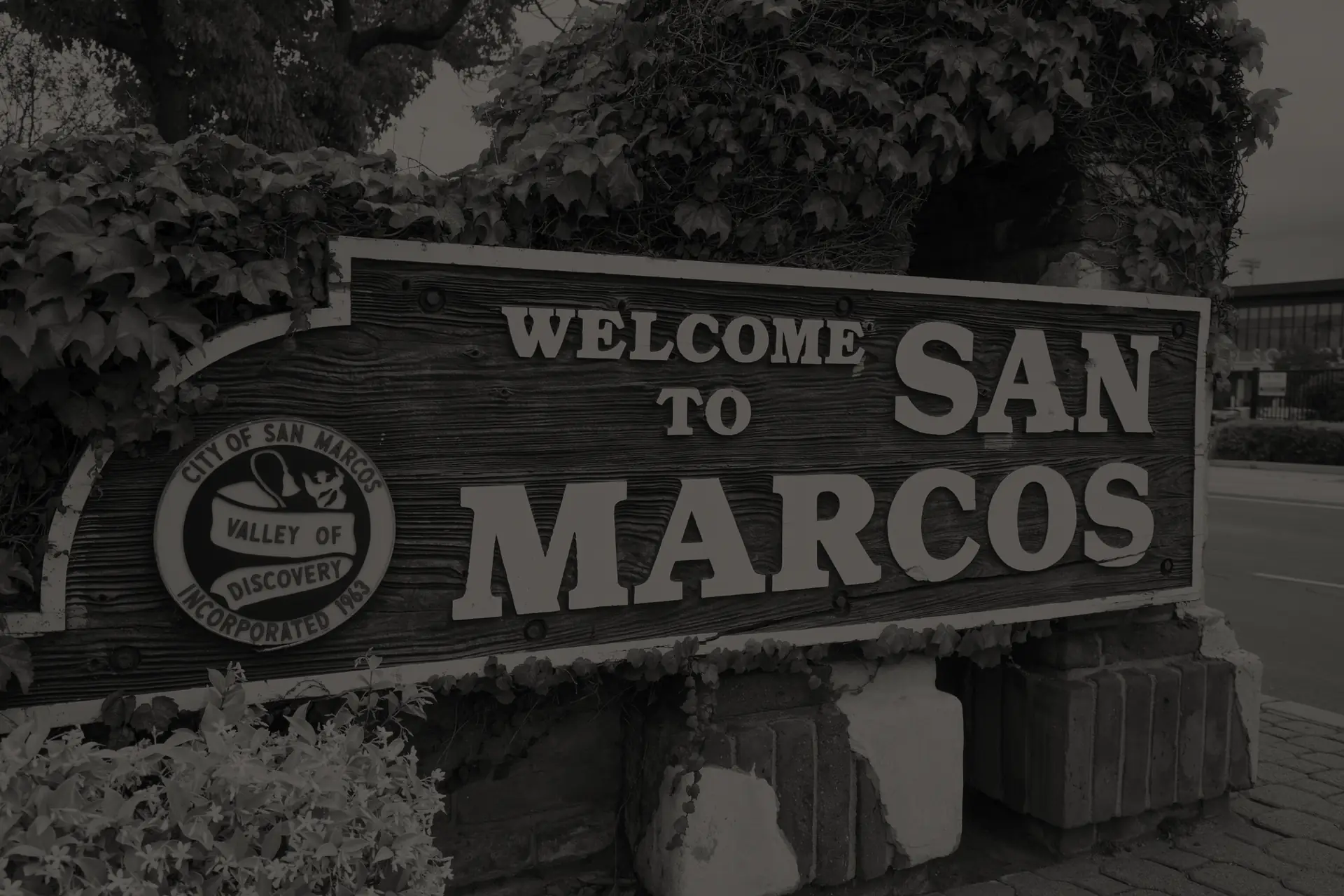The Welcome to San Marcos city sign on its ivy covered stone base in San Marcos, California.