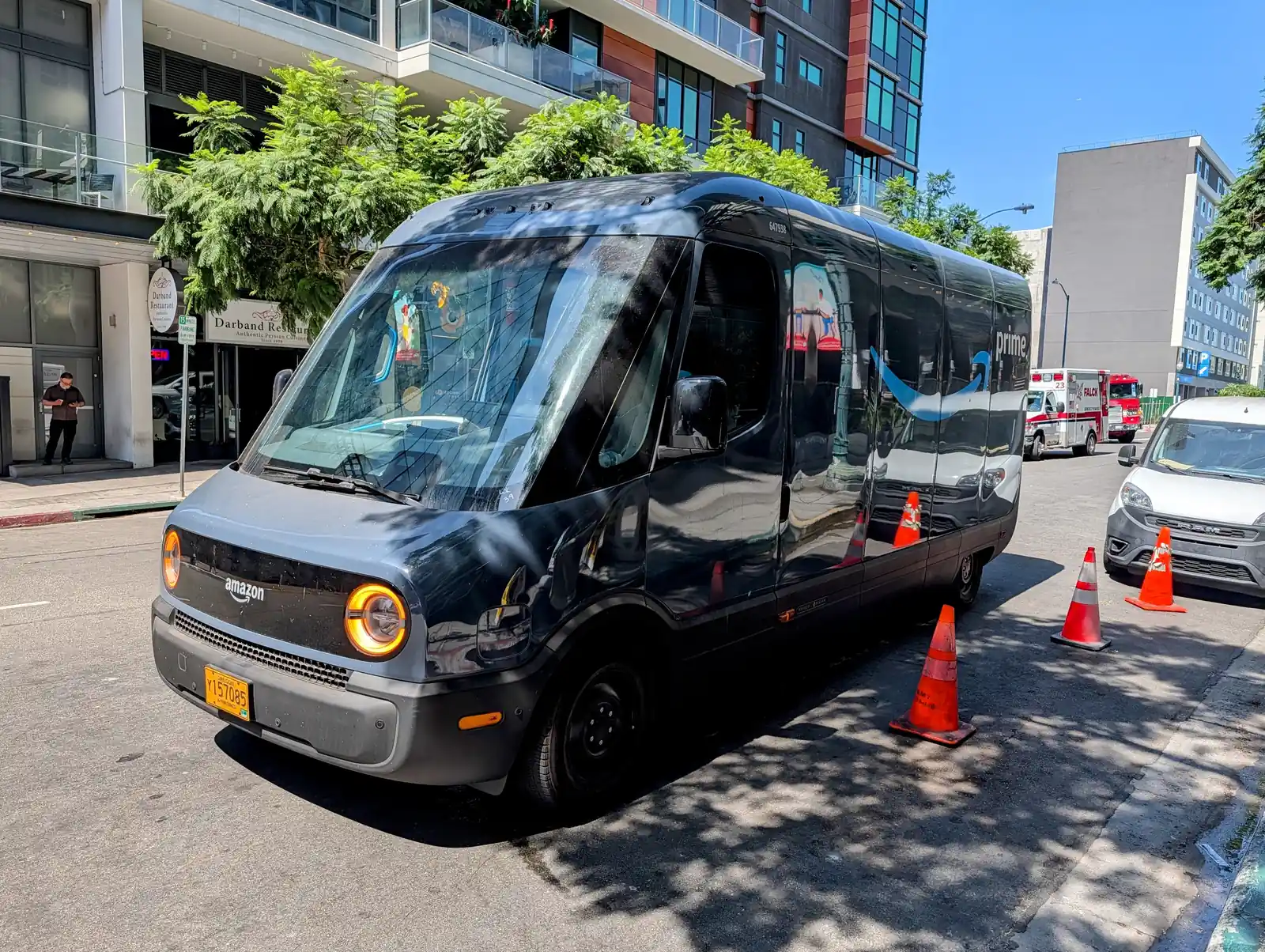 Amazon electric delivery van stopped at the curb with traffic cones in Little Italy, San Diego.