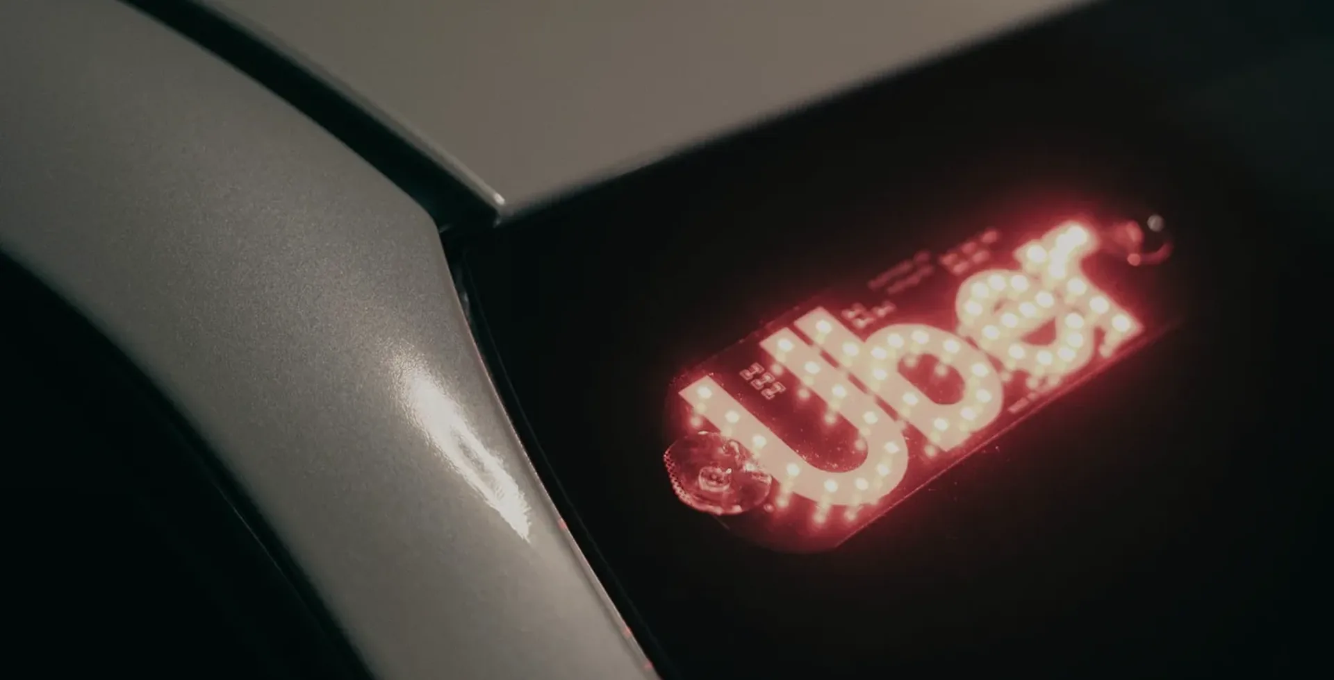 Illuminated Uber sign in a rideshare car’s rear window