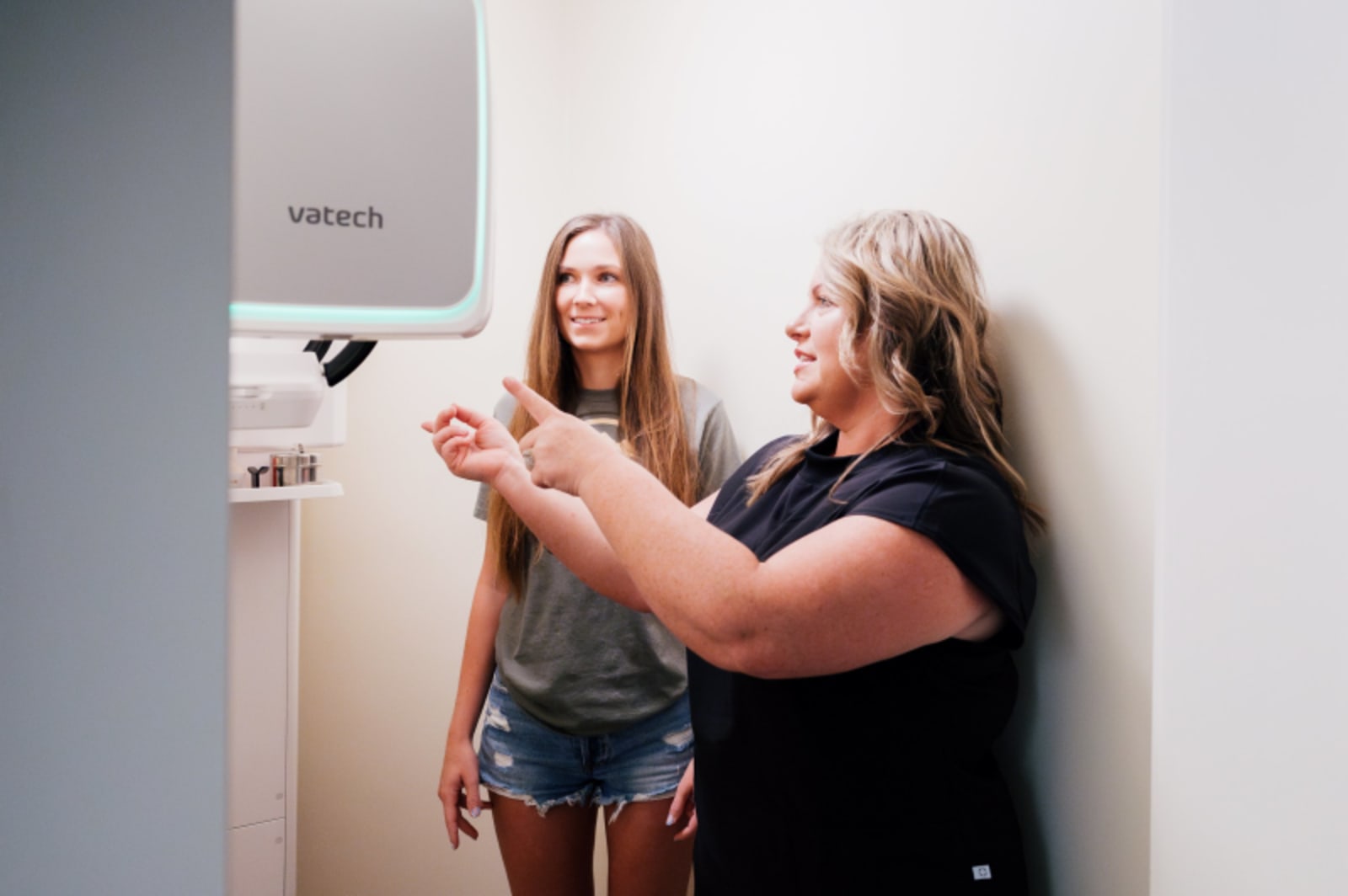 Dentist explaining X-ray results to female patient in treatment room