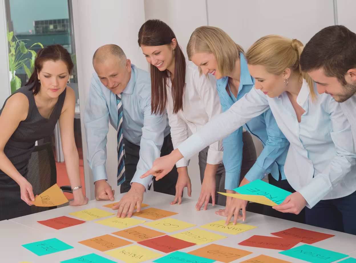 Team arbeitet gemeinsam mit bunten Karten an Kompetenzmatrix und Skill-Management-Workshop im modernen Büro.