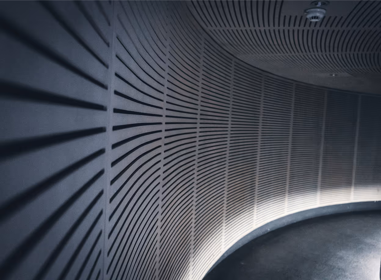 Geschwungene Decken- und Wandverkleidung mit präzisem Linienmuster als Sinnbild für strukturiertes Architekten Controlling im Planungsbüro.