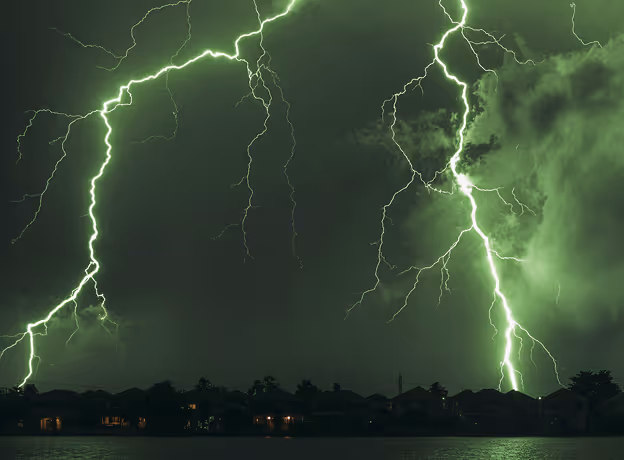 Grüne Gewitterblitze über einer Stadt bei Nacht als Sinnbild für unkontrollierte Budget-Burn-Rate in Projekten.