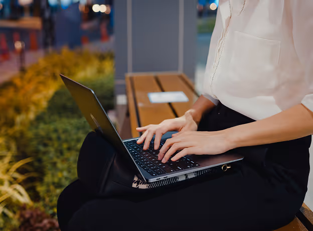 Freelancerin arbeitet mobil auf einem Laptop – symbolisiert flexiblen externen Ressourceneinsatz im IT-Projekt.