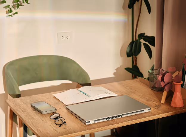 Aufgeräumter Homeoffice-Arbeitsplatz mit Laptop, Notizbuch und Smartphone auf Holzschreibtisch – Symbol für strukturiertes Arbeiten im Remote-Setup.