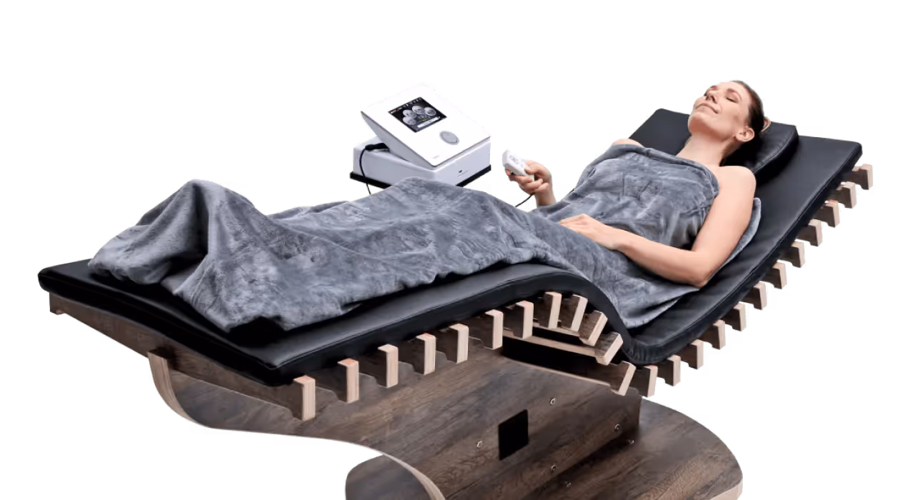 Frau genießt eine entspannende Therapie auf der reLounge Liege, die Wärmetherapie und EMS zur Schmerzlinderung kombiniert.