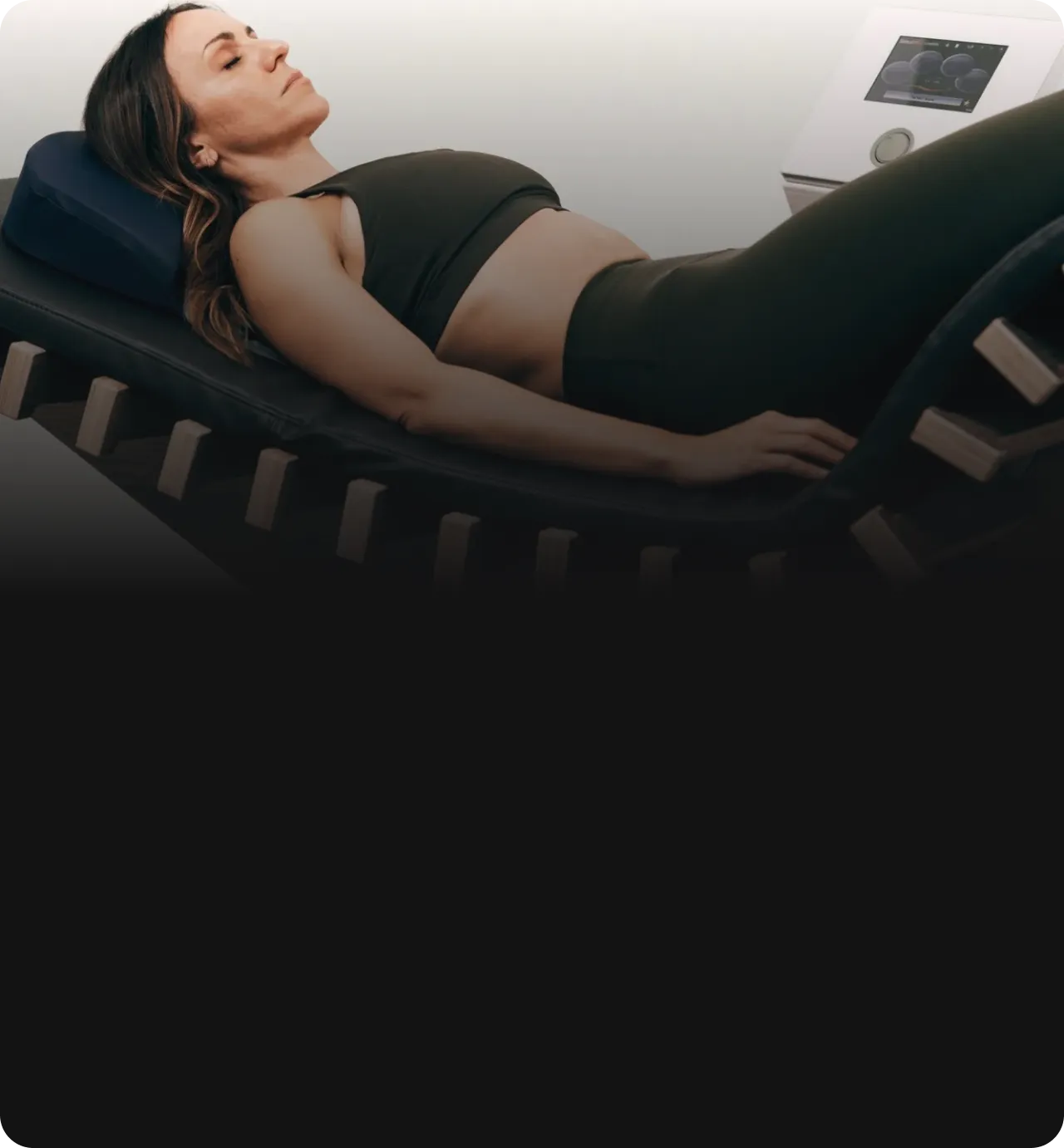 Frau entspannt auf der reLounge Liege mit integrierter Rückenschmerztherapie und moderner Technologie für optimale Tiefenentspannung und Schmerzlinderung.