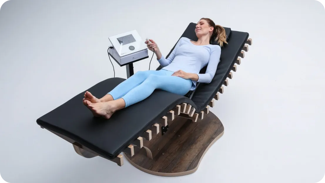 Frau genießt eine entspannende Therapie auf der reLounge Liege, die Wärmetherapie und EMS zur Schmerzlinderung kombiniert.