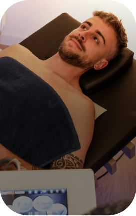 Mann entspannt auf relounge Regenerationsliege bei EMS-Anwendung – smarte Muskeltherapie mit moderner Touchscreen-Steuerung.