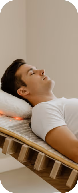Mann entspannt auf der relounge Regenerationsliege mit Infrarotlicht – smarte EMS-Technologie zur Muskelentspannung und Stressreduktion.
