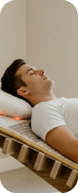 Mann entspannt auf der relounge Regenerationsliege mit Infrarotlicht – smarte EMS-Technologie zur Muskelentspannung und Stressreduktion.