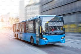 Blue city bus in motion on an urban street representing free public transit and improved access to essential services.