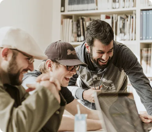 Group of young people looking at screen and laughing