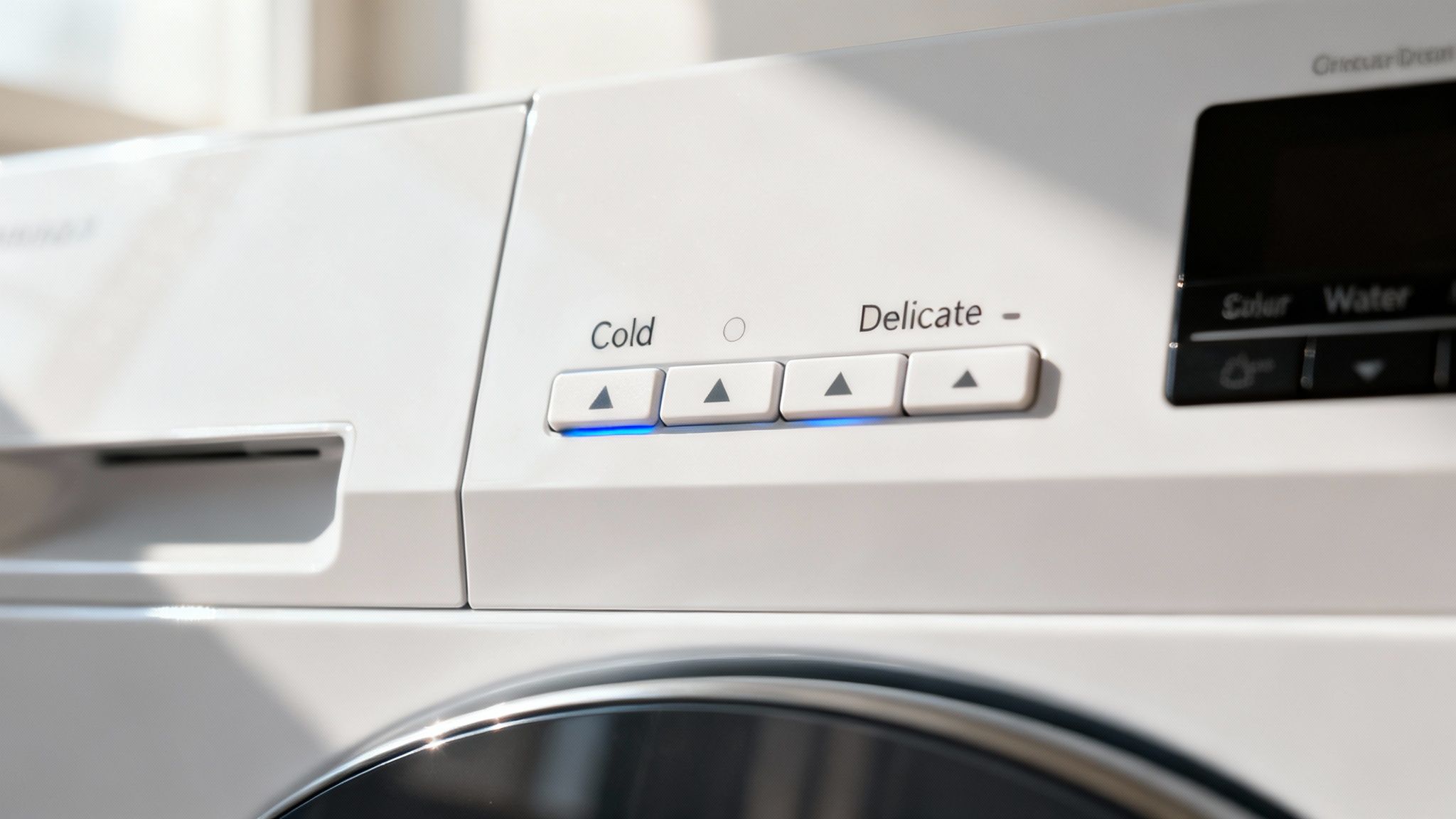 Close-up of a modern washing machine control panel, with a hand about to select a setting.