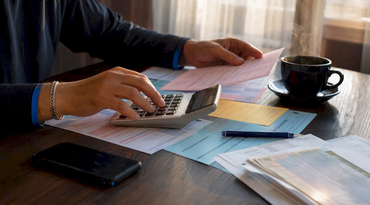 Hands calculating laundry service invoices overhead