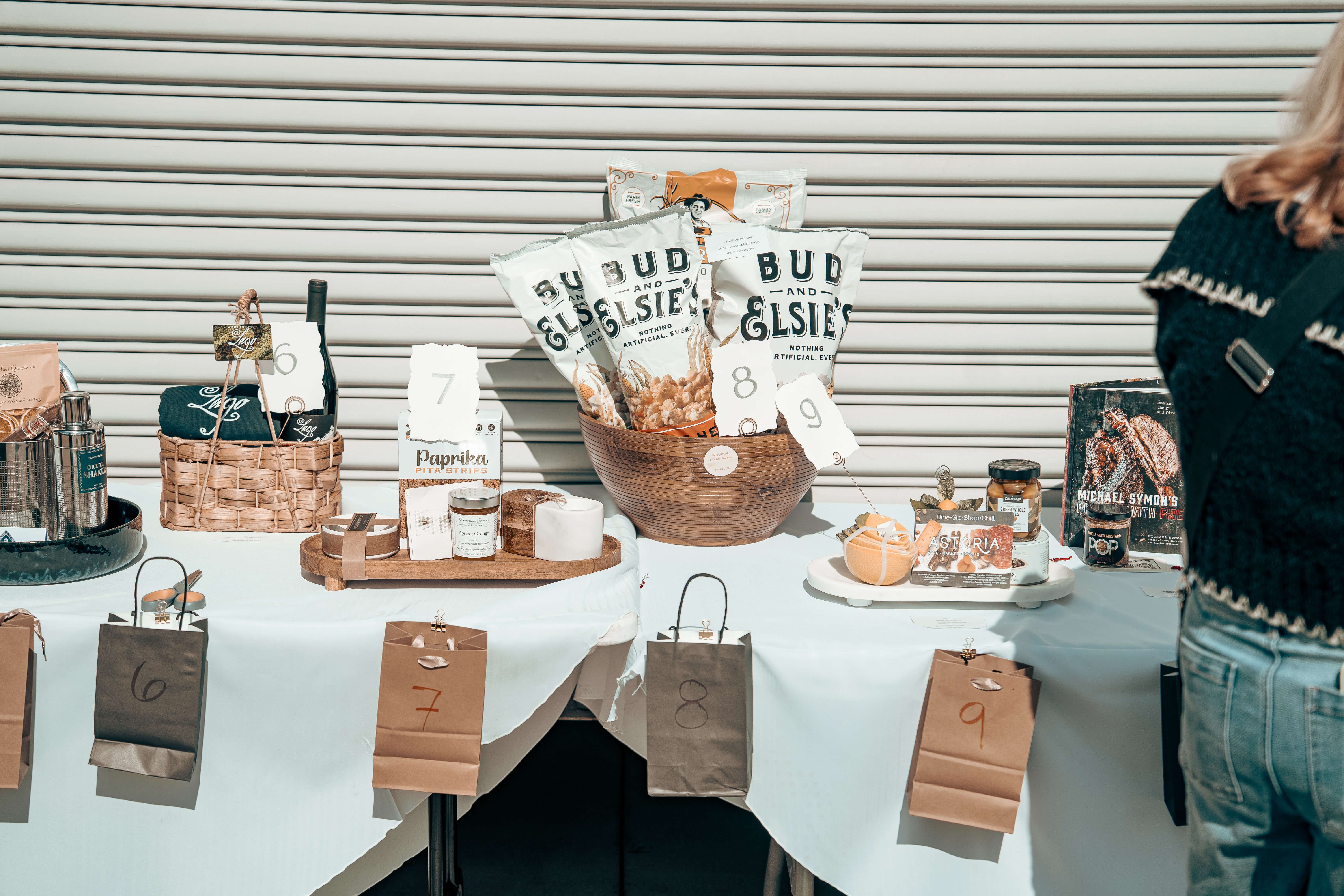 Numbered gift bags and Bud and Elsie's snacks on a white display table