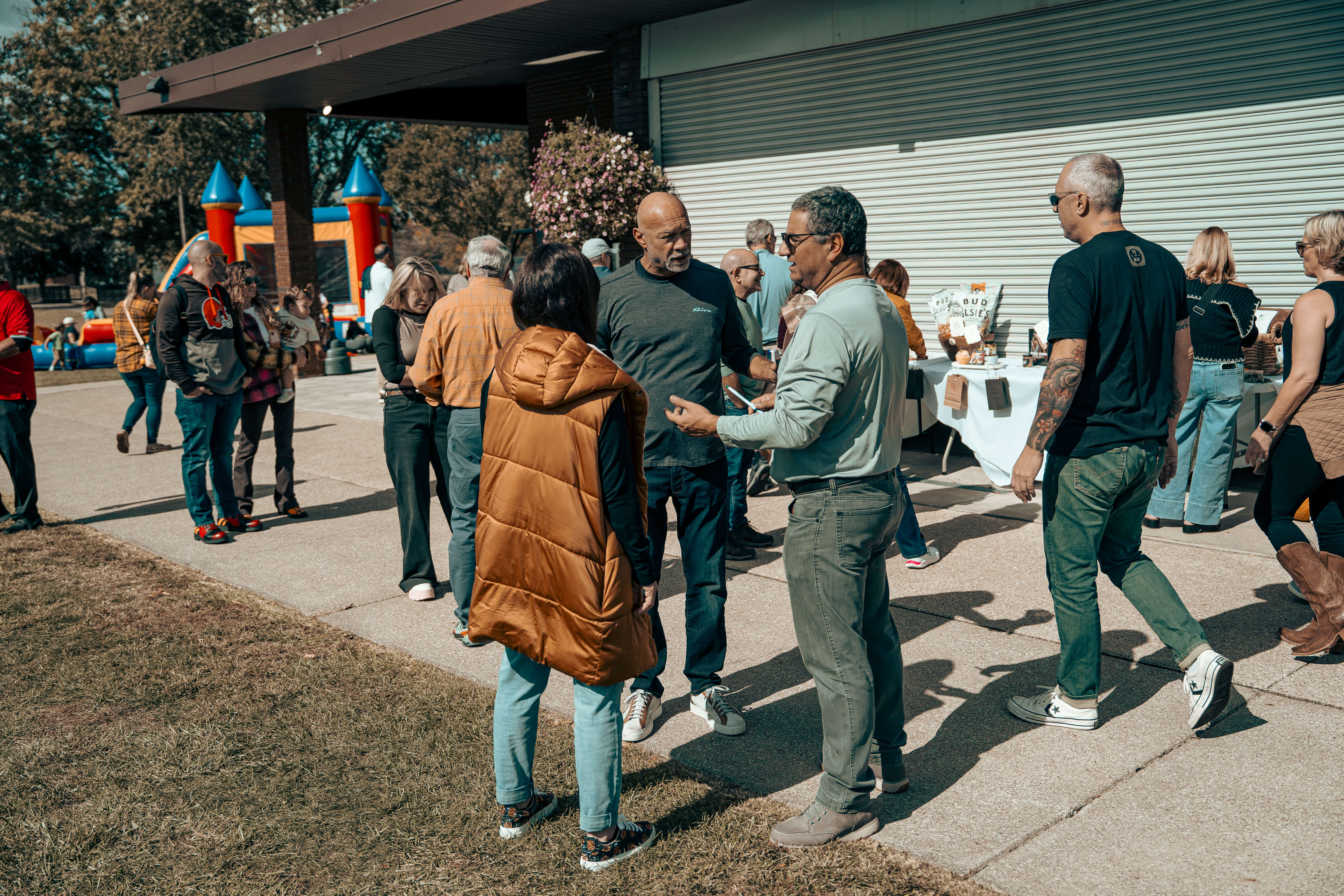 Older adults gather outside near inflatable bounce house at community event