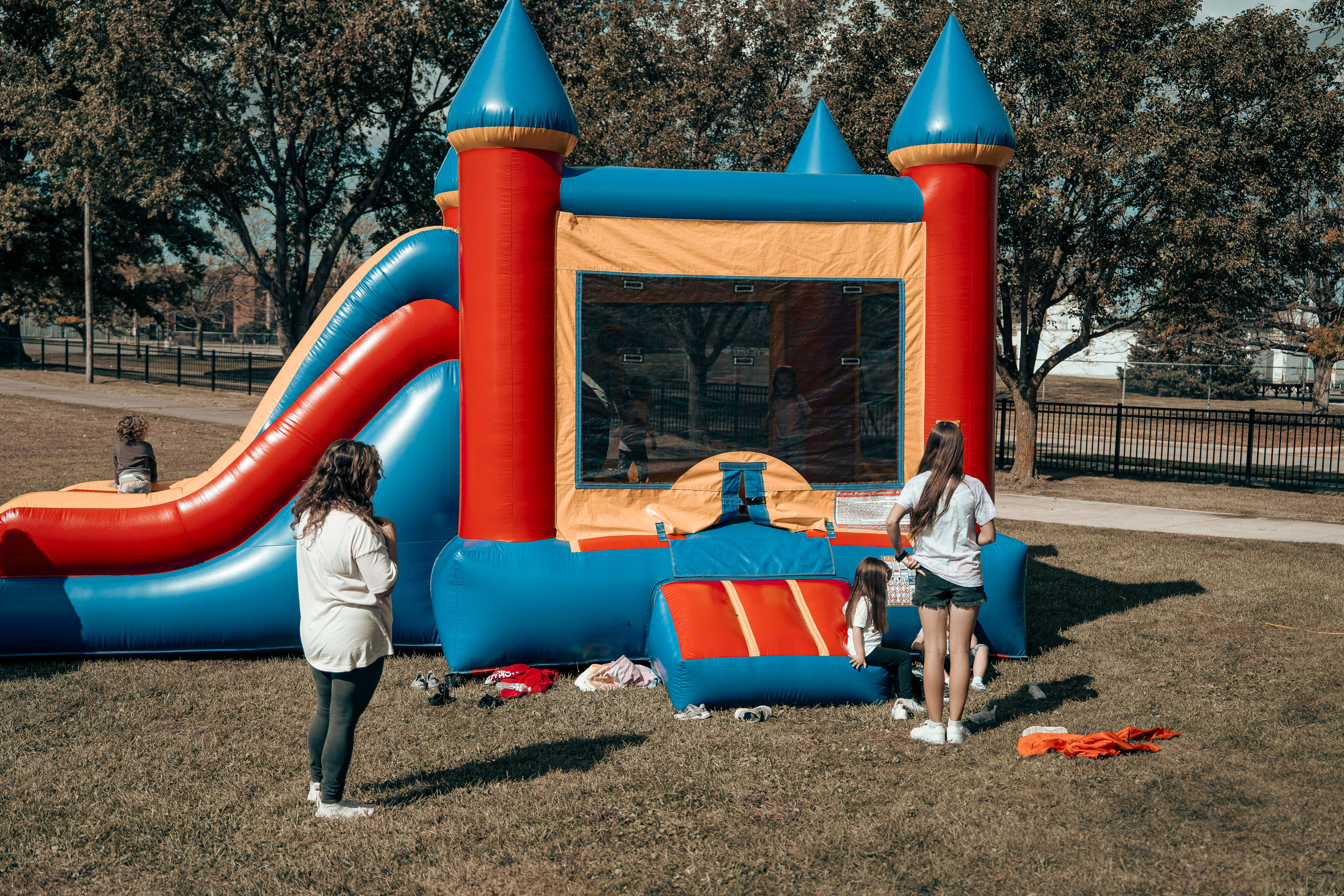 Colorful inflatable bounce house with slide in park setting