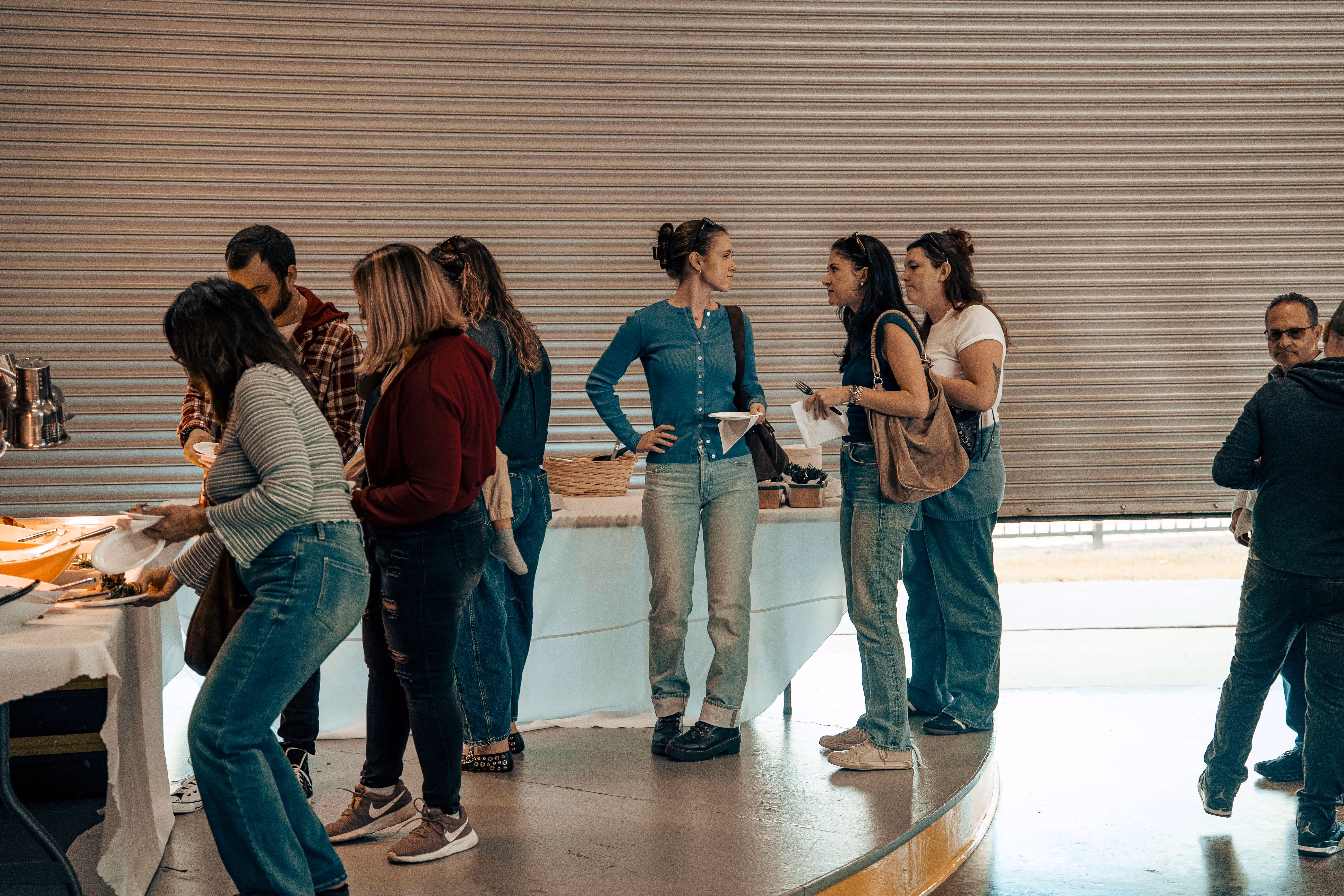 Group of people gathered around table with food and conversations