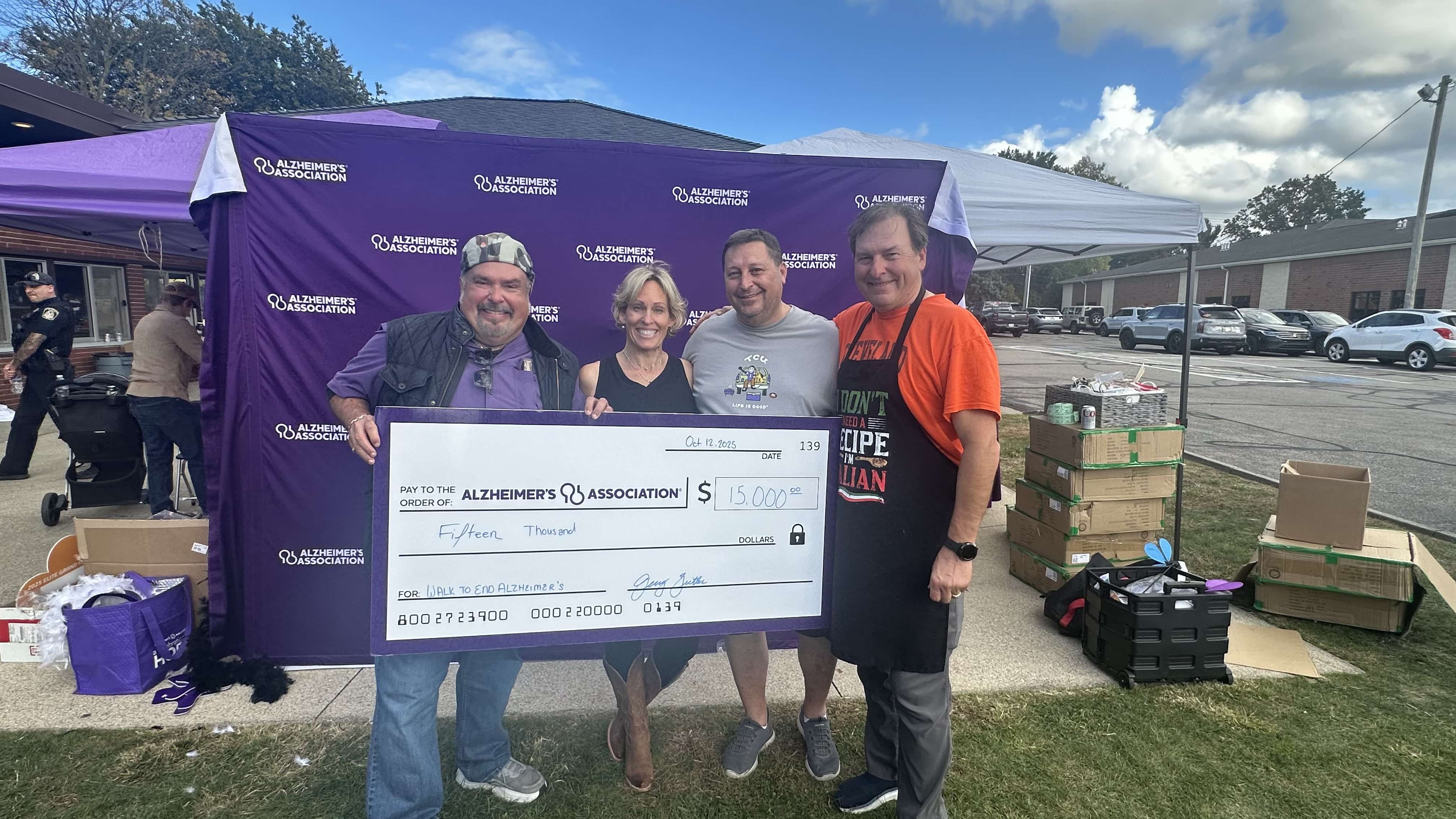 Volunteers pose with $15,000 donation check for Alzheimer's Association