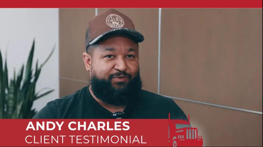 Andy Charles giving a client testimonial video interview, wearing a trucker hat and a prominent beard. 