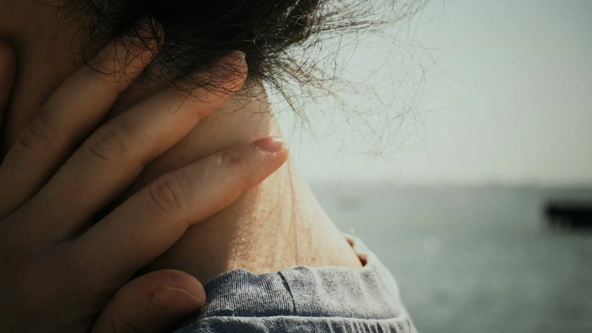 Close up of woman holding her neck