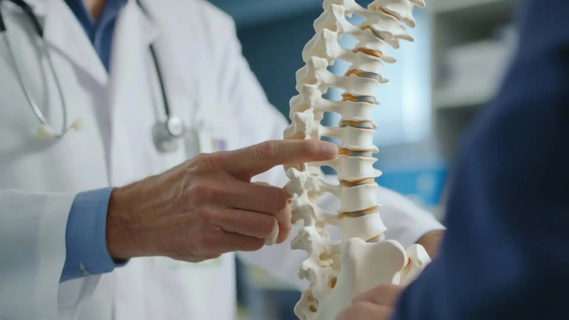 Doctor pointing to spine model to show spinal cord injury